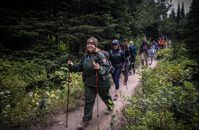 trail-hike A ranger leading group of hikers down a trail.