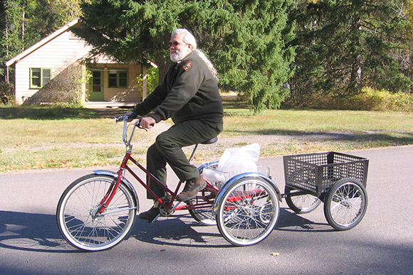 A ranger riding a red tricycle.