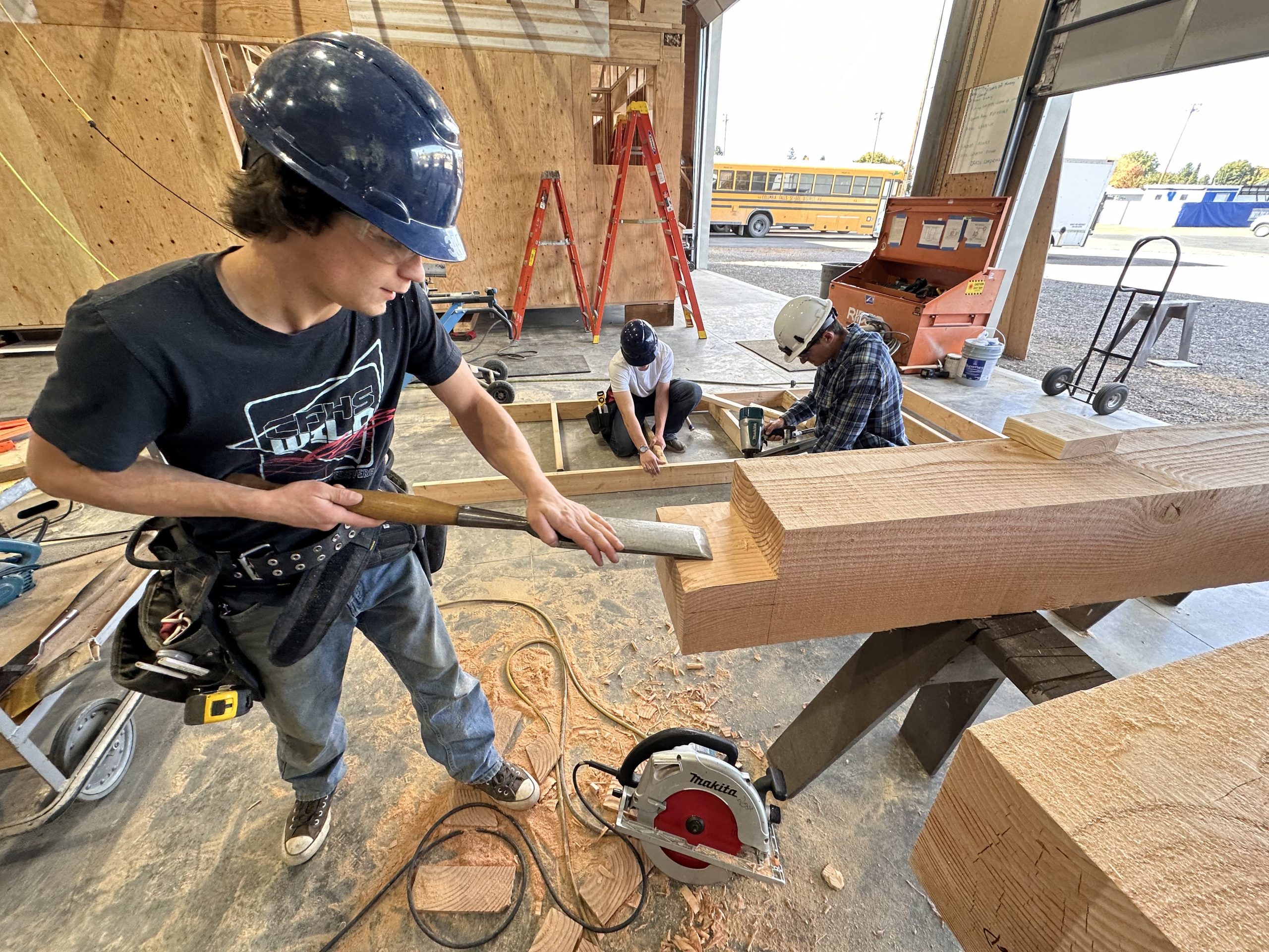 A student prepares a beam for use in construction.