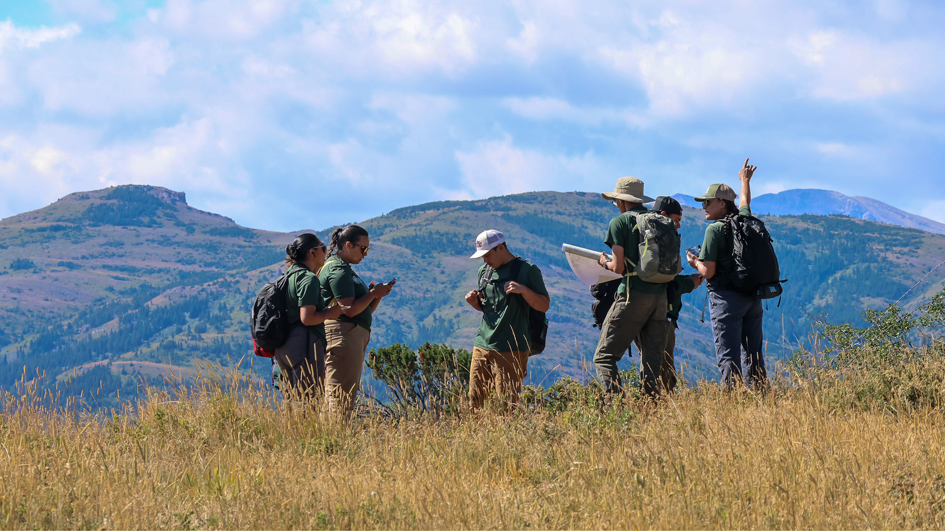 A group of corps members looking up at mountains and the sky.